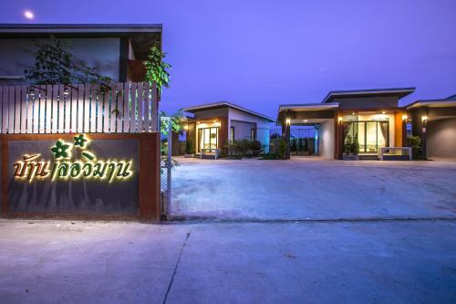an empty parking lot in front of a building at night at Baan Le Vimaan in Nakhon Ratchasima