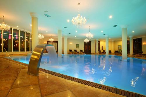 una piscina en un hotel con lámparas de araña en Arcadia Hotel - Marina Regia Residence, en Mamaia Nord – Năvodari