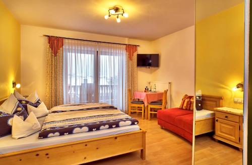 a bedroom with a bed and a red chair at Rehwinkel in Bodenmais