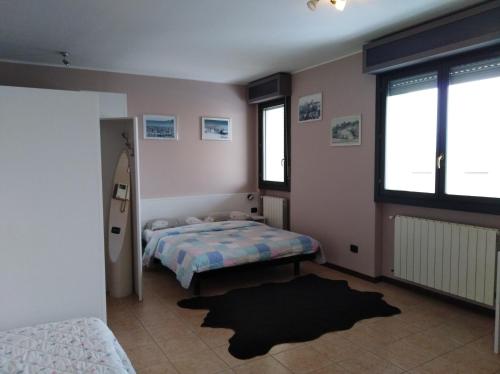 a bedroom with two beds and two windows at Airport Orio Studio in Bergamo