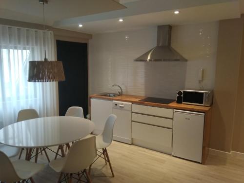 a kitchen and dining room with a table and a table and chairs at Apartamento centro Ribadeo in Ribadeo