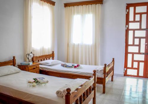 1 dormitorio con 2 camas y ventana en Pelagion II Sea Coral - Beachfront holiday home en Kipseli