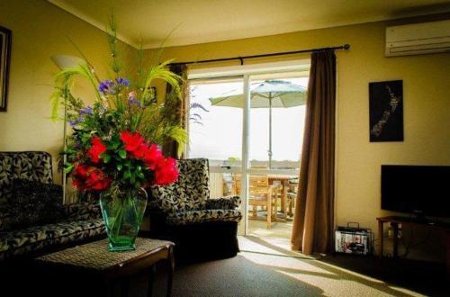 a living room with a vase of flowers on a table at The Nunnery in Te Aroha