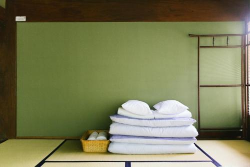 a stack of towels in a room with a basket at Retreat wabi-sabi - walk to Ohama Beach - Max 12 ppl in Shimoda
