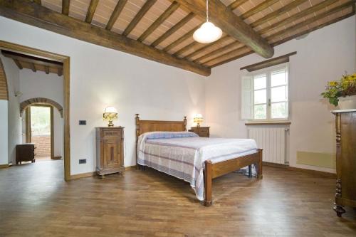 a large bedroom with a bed and a wooden ceiling at Villa Broccolo in Capannori