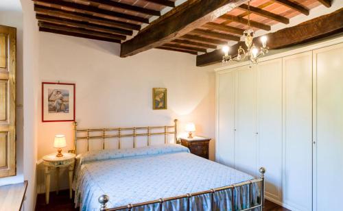 Valgiano的住宿－托尼奧別墅，一间卧室配有一张床、两张桌子和两盏灯。