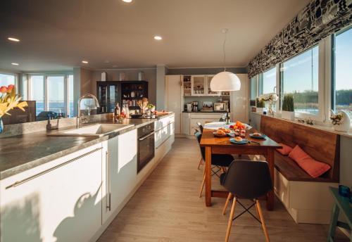 a kitchen with white cabinets and a wooden table at Goitzsche Resort in Bitterfeld