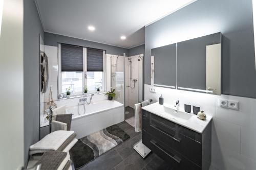 a bathroom with a large tub and a sink at Goitzsche Resort in Bitterfeld