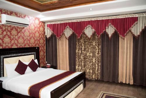 a bedroom with a bed with red wallpaper at Premier Inn Davis Road Lahore in Lahore