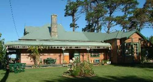 a large brick house with a green lawn in front of it at Butterfly Farm Bed and Breakfast Nirranda in Nirranda