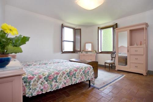 a bedroom with a bed and a dresser and a mirror at La Fonte by Salogi Villas in Palaia