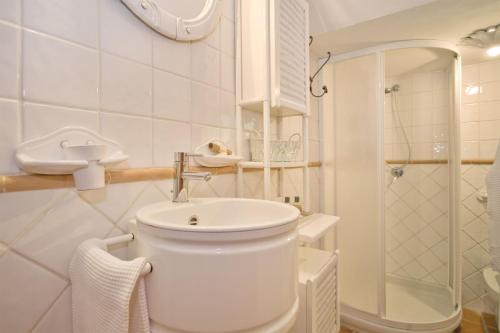 a white bathroom with a toilet and a sink at La Fonte by Salogi Villas in Palaia