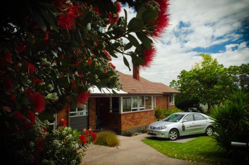a house with a car parked in the driveway at The Nunnery in Te Aroha
