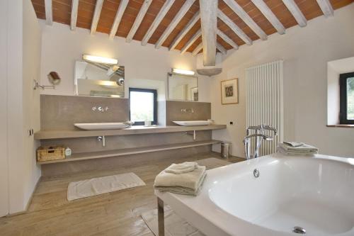 a large bathroom with a tub and two sinks at La Maccinaia by Salogi Villas in Monte Benichi