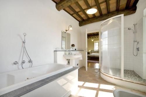 a white bathroom with a tub and a sink at Villa Teto in Collodi