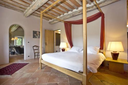 a bedroom with a canopy bed in a room at La Maccinaia by Salogi Villas in Monte Benichi