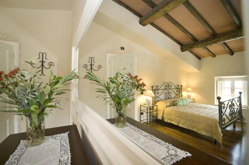a bedroom with a bed and two tables with flowers at Villa Teto in Collodi