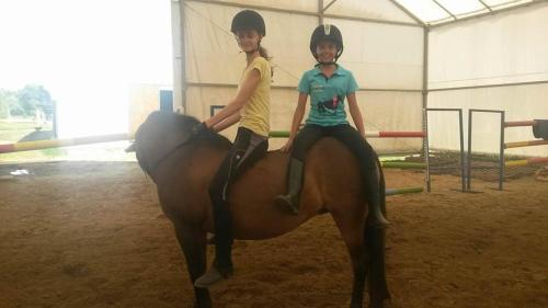 two young girls are sitting on a horse at Caballus Lovasmajor Panzió in Nyíregyháza