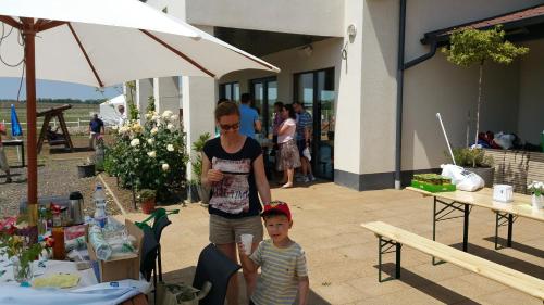 a woman and a child standing under an umbrella at Caballus Lovasmajor Panzió in Nyíregyháza