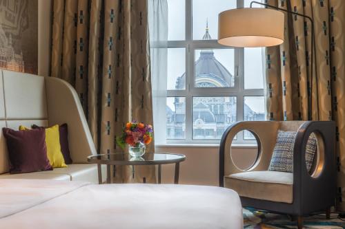 a hotel room with a bed and a chair and a window at Radisson Blu Hotel, Antwerp City Centre in Antwerp