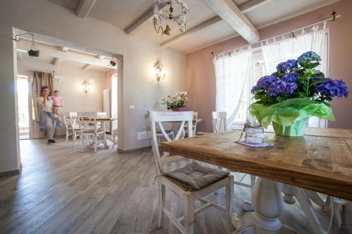a dining room with a table with purple flowers on it at Casa Al Fiume in Ponti Sul Mincio