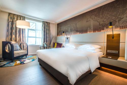 a bedroom with a large white bed and a chair at Radisson Blu Hotel, Antwerp City Centre in Antwerp