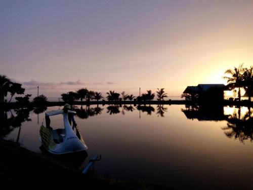 a boat on the water with the sunset in the background at Chattong resort in Trat