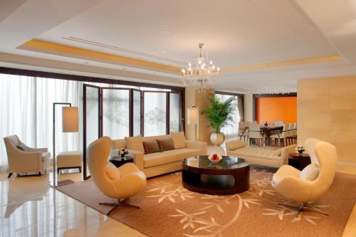 a living room with a couch and chairs and a table at Radisson Blu Plaza Chongqing - Free one cup of smoky the gelnlivet during stay in Chongqing
