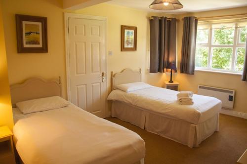 a bedroom with two beds and a window at Riverside Holiday Homes in Aughrim