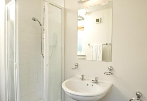 a white bathroom with a sink and a shower at Riverside Holiday Homes in Aughrim