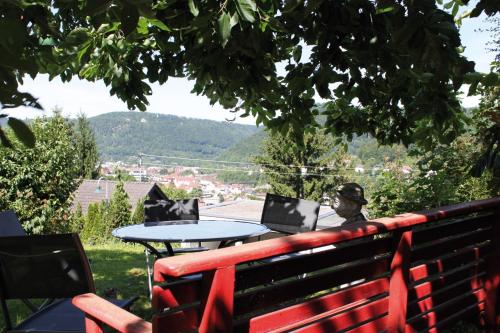 a man sitting on a bench with a table with laptops at Panoramablick vom Obergeschoß in Geislingen an der Steige