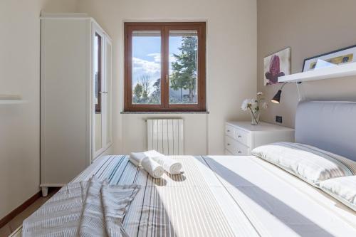 una camera bianca con un letto e una finestra di Alessandra 2 Apartment by Wonderful Italy a Padenghe sul Garda