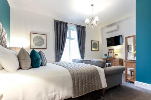 a bedroom with a large bed and a window at Tyndale B&B Torquay in Torquay