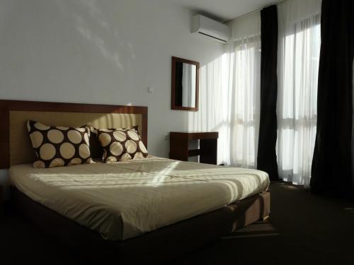 una camera da letto con un letto con cuscini sopra di Yuliya Guest House a Sapareva Banya