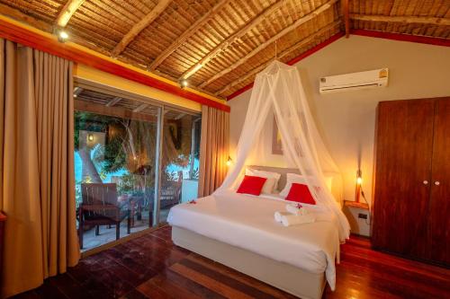 a bedroom with a bed and a balcony at Secret Garden Beach Resort in Bangrak Beach
