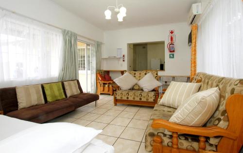 sala de estar con 2 sofás y cocina en Clinch Self Catering, en Durban