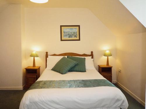 a bedroom with a large bed with two lamps at Ballybunion Holiday Cottages in Ballybunion