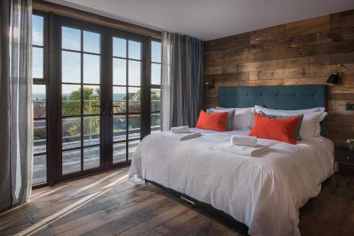 a bedroom with a large bed with red pillows at Merchants Manor Spa in Falmouth