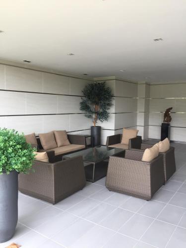 a lobby with couches and a table and plants at Meridin Medini Muslim Condo in Nusajaya