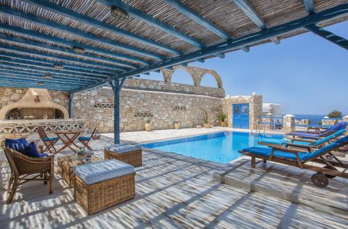 a patio with a pool and lounge chairs and a swimming pool at Villa Celestia in Ornos