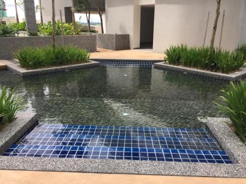 a pool of water with blue tiles in a building at Meridin Medini Muslim Condo in Nusajaya