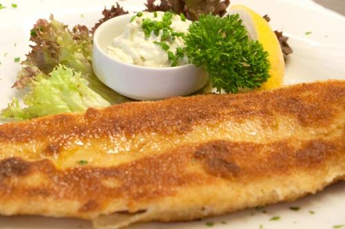 a plate of food with a piece of fish and a salad at Gasthof Fischerstüberl in Rottau
