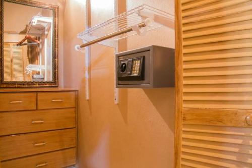 uma casa de banho com um micro-ondas, uma cómoda e um espelho. em One32 Guesthouse Red Velvet em Kingston