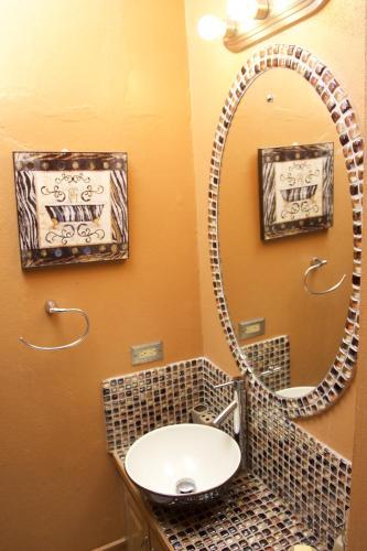 a bathroom with a sink and a mirror at One32 Guesthouse Red Velvet in Kingston