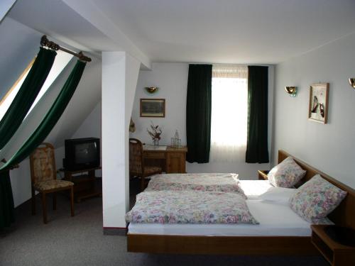 a bedroom with a bed and a window and a television at Landhaus Hohenroda in Hohenroda