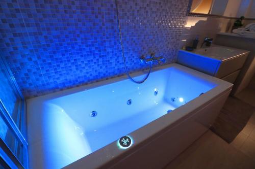 a bathroom with a tub with a blue tiled wall at Estate4home - Casa Rosangela in Sorrento