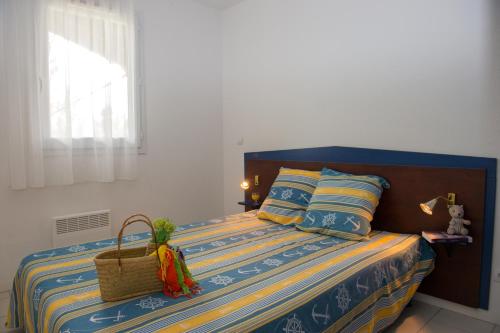 Un dormitorio con una cama con una cesta. en Résidence Goélia La Marina de Talaris, en Lacanau