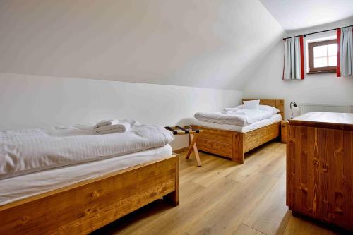 two twin beds in a room with wooden floors at Rezort Gothal Chalupy in Donovaly
