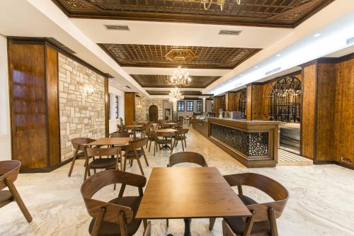 a restaurant with wooden tables and chairs and a fireplace at Hotel Onufri in Berat
