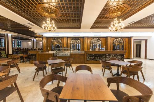 a restaurant with wooden tables and chairs and a bar at Hotel Onufri in Berat